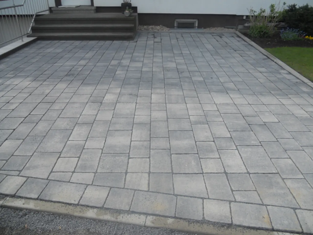 Großzügige, neu gepflasterte Terrasse aus grauen Platten