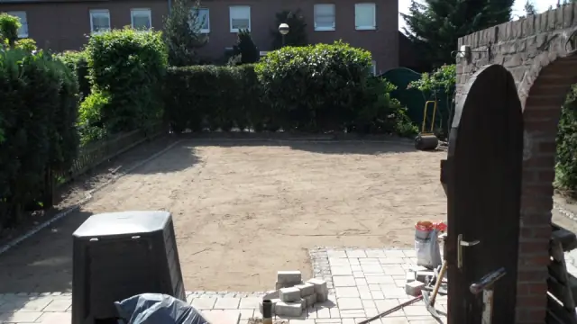 Leergeräumter Garten mit Backsteinbogen vor der Neugestaltung