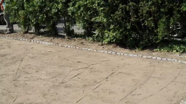 Kantsteine ziehen den geschwungenen Verlauf eines neuen Beetes
