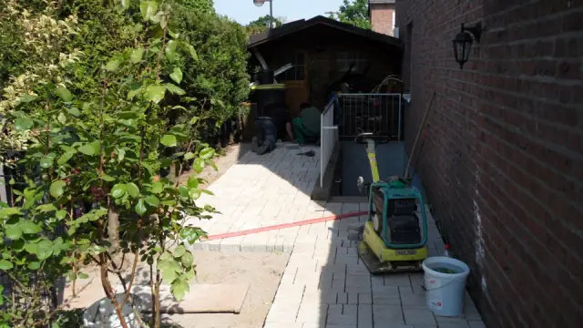 Schmaler Seitengarten mit neu verlegtem Plattenweg