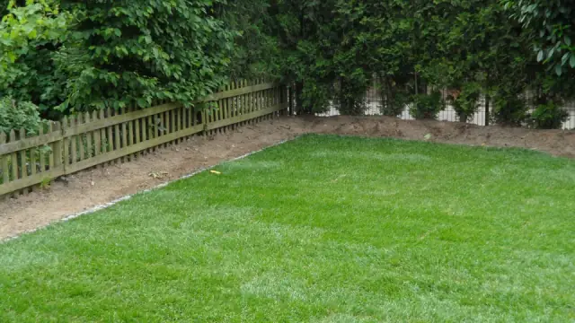 Fertiger Gartenrasen mit Holzzaun als Grundstücksabgrenzung